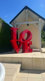 Statue LOVE rouge en métal exposée dans un jardin moderne