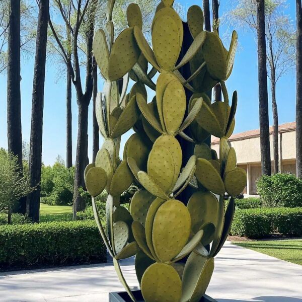 Grande sculpture de cactus en métal sur terrasse avec vue arborée