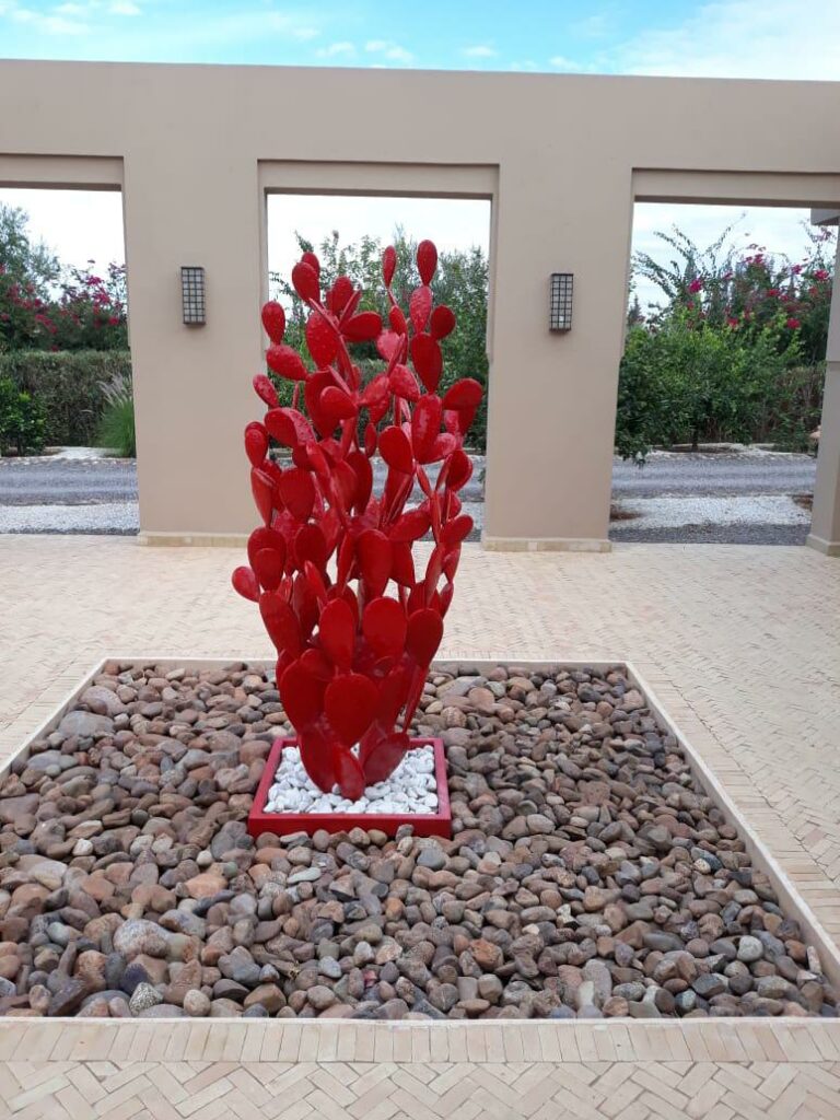 Sculpture cactus rouges en métal dans une cour extérieur contemporain