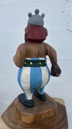 Vue de profil de la sculpture en bois d’Obélix, personnage de bande dessinée gauloise