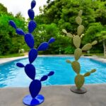 Sculptures design en métal bleu et vert en forme de cactus près d'une piscine contemporaine