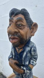 Détail du visage sculpté de Serge Gainsbourg en bois, expression réaliste et travaillée à la main