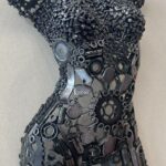 Sculpture murale représentant un torse féminin en métal recyclé, œuvre artistique contemporaine