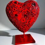 Sculpture cœur rouge en métal avec pièces mécaniques et outils
