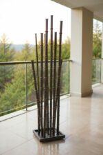 Sculpture de bambou en métal installée sur balcon avec vue sur nature