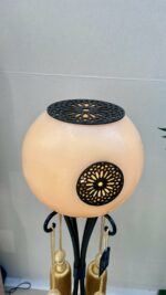 Lampe design lumineuse ronde en cire ambre avec structure en métal et finitions ajourées