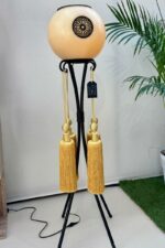 Lampe ronde en métal avec abat-jour en cire couleur ambre, ornée de pompons dorés, style oriental moderne