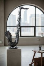 Sculpture en métal représentant un saxophone industriel exposé dans un loft urbain